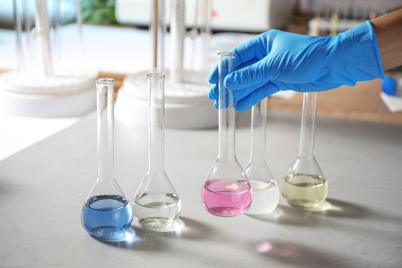 Scientist,Taking,Flask,With,Colorful,Liquid,From,Table,Indoors,,Closeup.